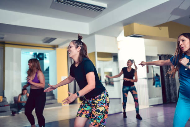 Happy Female Athlete Enjoying Dance Workout With Friends